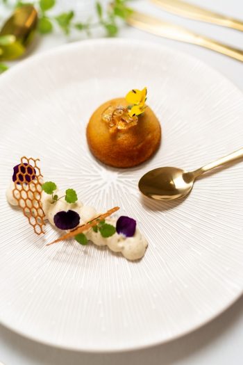 Chocolat blond & fleurs du potager Moelleux chocolat blond, ganache montée jasmin, pétales & herbes du jardin, croustillant sarrasin, gel fleur de sureau.